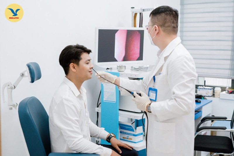 Bác sĩ tai mũi họng đang khám cho bệnh nhân, lời khuyên quan trọng khi các triệu chứng đau họng, ho kéo dài dù đã dùng xịt họng con ong
