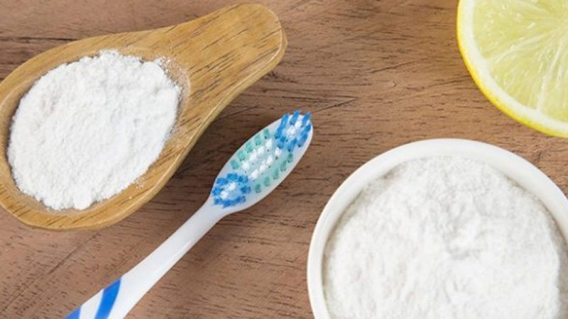 Bàn chải đánh răng và tuýp kem đánh răng chứa baking soda trên nền trắng, minh họa cách dùng đúng