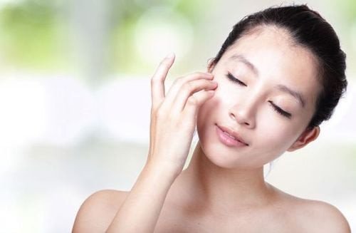 Chai kem dưỡng ẩm da mặt nhỏ gọn cạnh một bông hoa, biểu tượng cho sự tinh tế và đặc trị cho làn da nhạy cảm