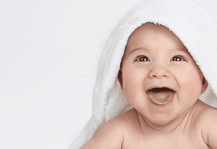Hình ảnh em bé 8 tháng tuổi đang cười, thể hiện tình trạng trẻ chậm mọc răng có thể do nhiều yếu tố.