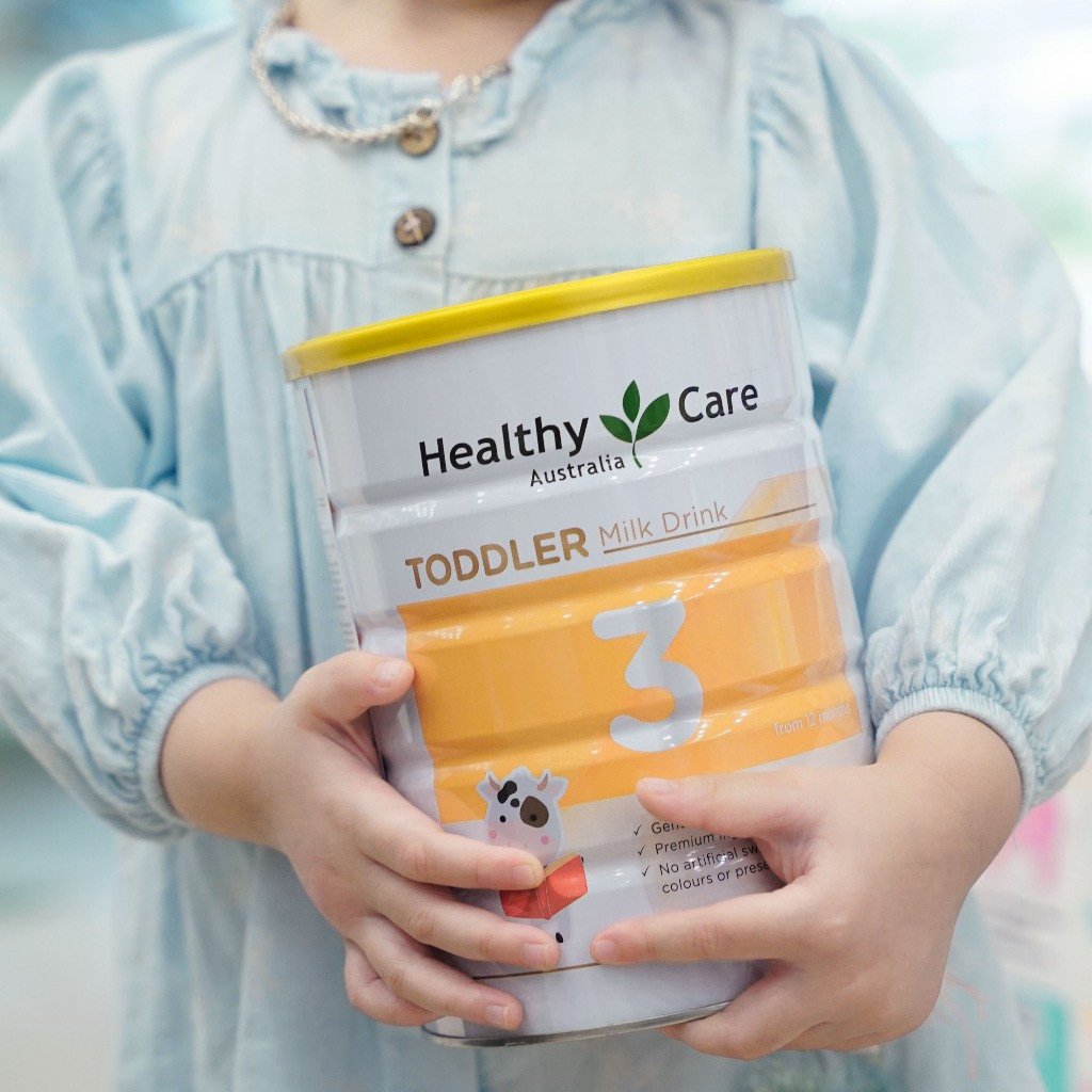 Hình ảnh mẹ cho bé uống sữa Healthy Care số 3, phản ánh sự tin dùng