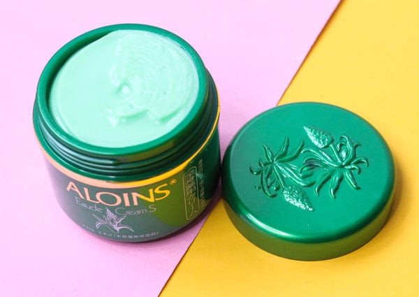 Hộp kem dưỡng ẩm Aloins màu xanh lá với kết cấu đặc sánh, giàu dưỡng chất.