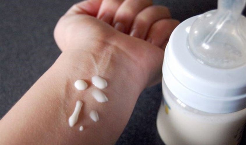 Kiểm tra nhiệt độ sữa Aptamil trên mu bàn tay trước khi cho bé bú