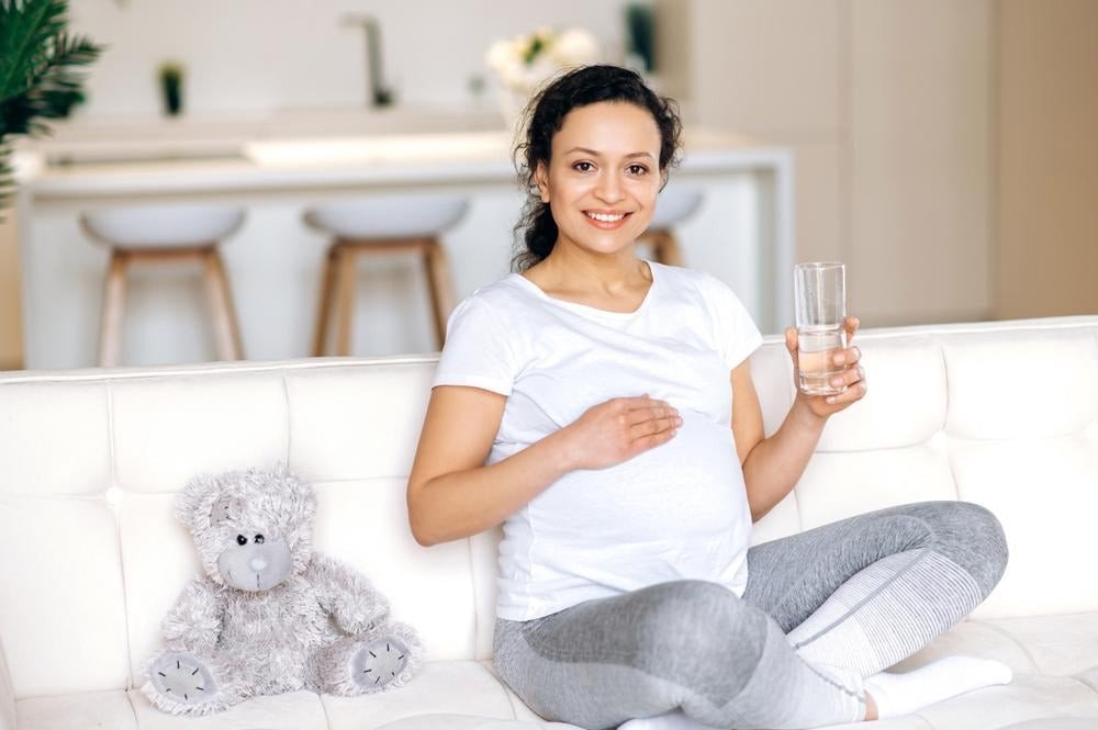Mẹ bầu cười vui vẻ, bụng bầu lớn, biểu tượng của sự khỏe mạnh khi mang thai