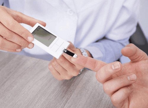 Người đàn ông kiểm tra đường huyết, liên quan đến lợi ích của viên uống giấm táo trong việc kiểm soát đường huyết.