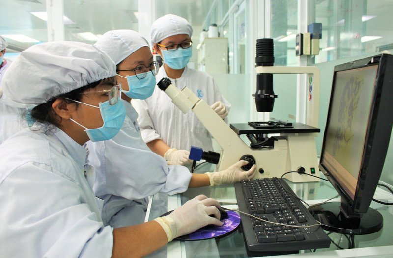 Người phụ nữ trẻ đang xem xét các loại thuốc, thể hiện sự băn khoăn về hiệu quả của liệu pháp vi lượng đồng căn và tác dụng giả dược.