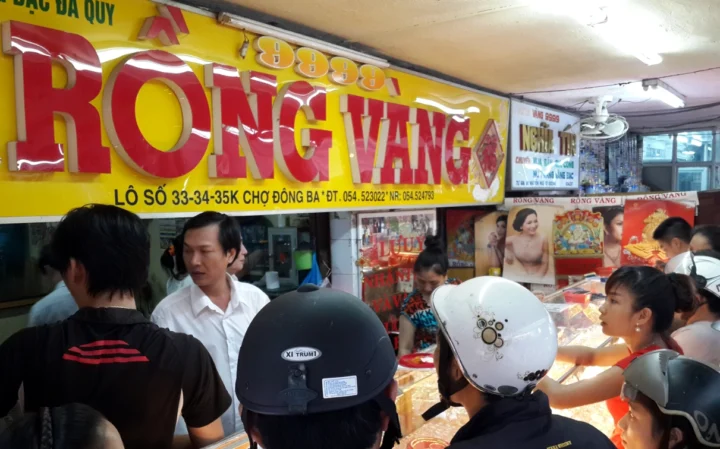 Người phụ nữ xem giá vàng